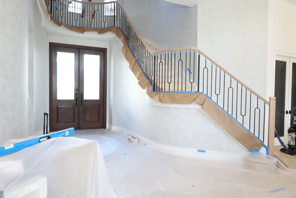 Curved staircase with white oak handrail and black steel pickets in a Palm Beach Gardens foyer