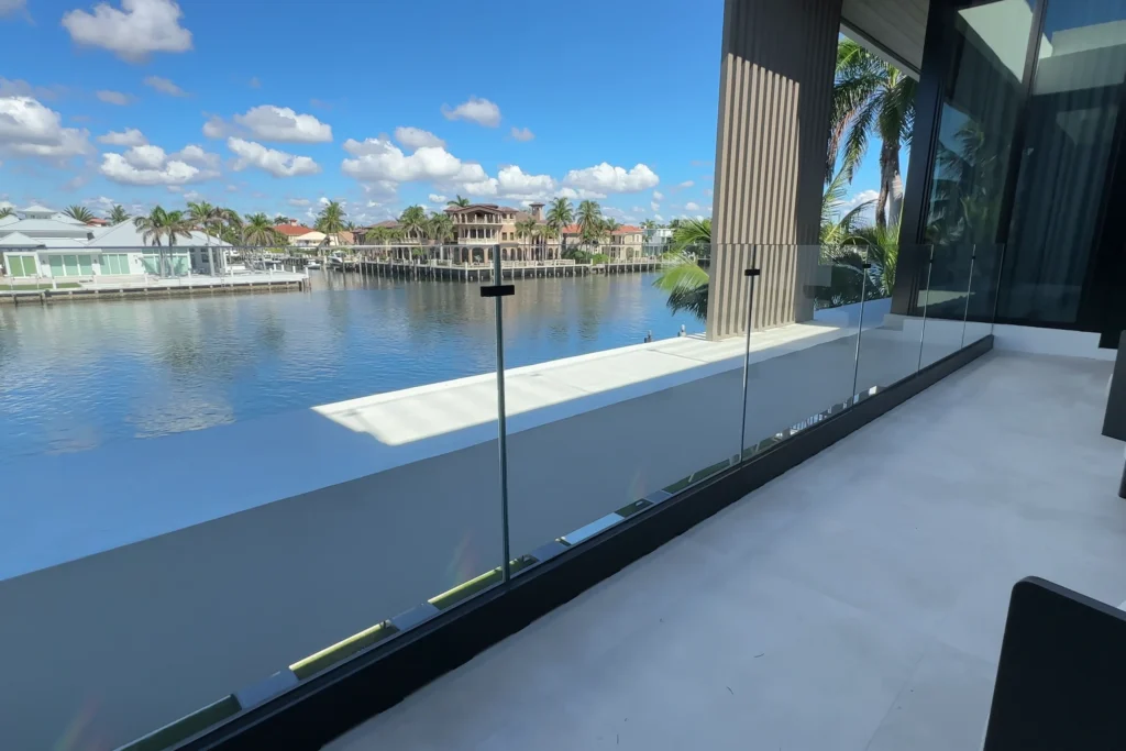 Low iron laminated glass railing in a base shoe on a waterfront terrace in Highland Beach