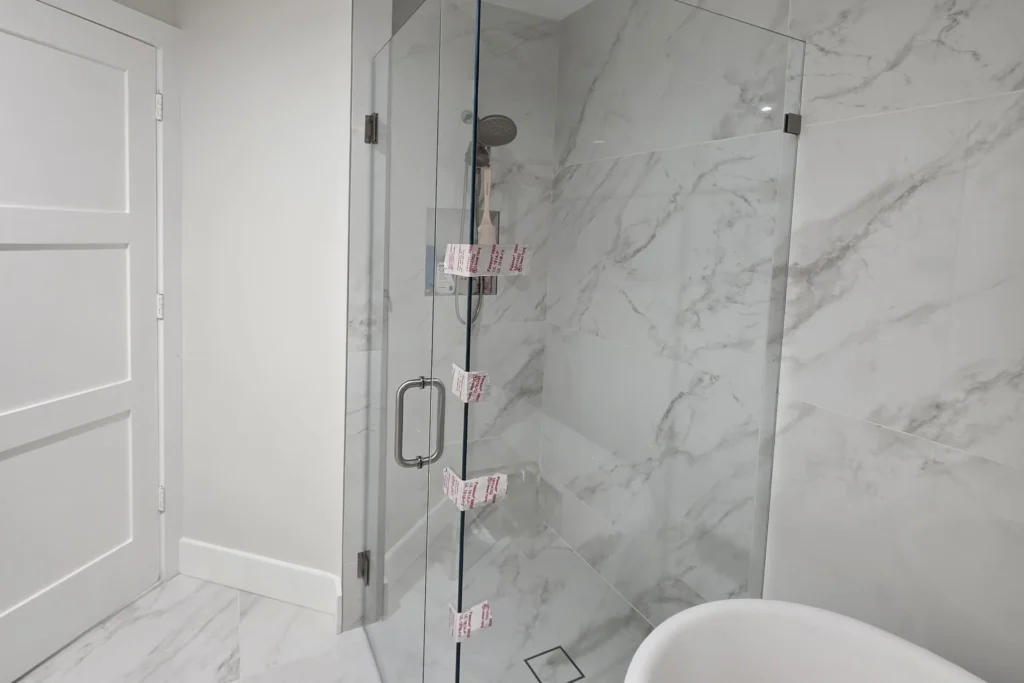 Low iron frameless glass shower enclosure with brushed nickel hardware, Saint Tropez Circle residence, West Palm Beach