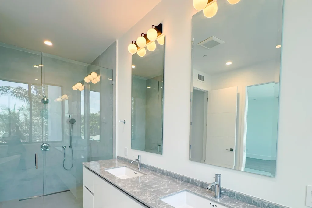 Pair of custom frameless vanity mirrors above a double vanity in a Delray Beach home by ACG Glass & Metals