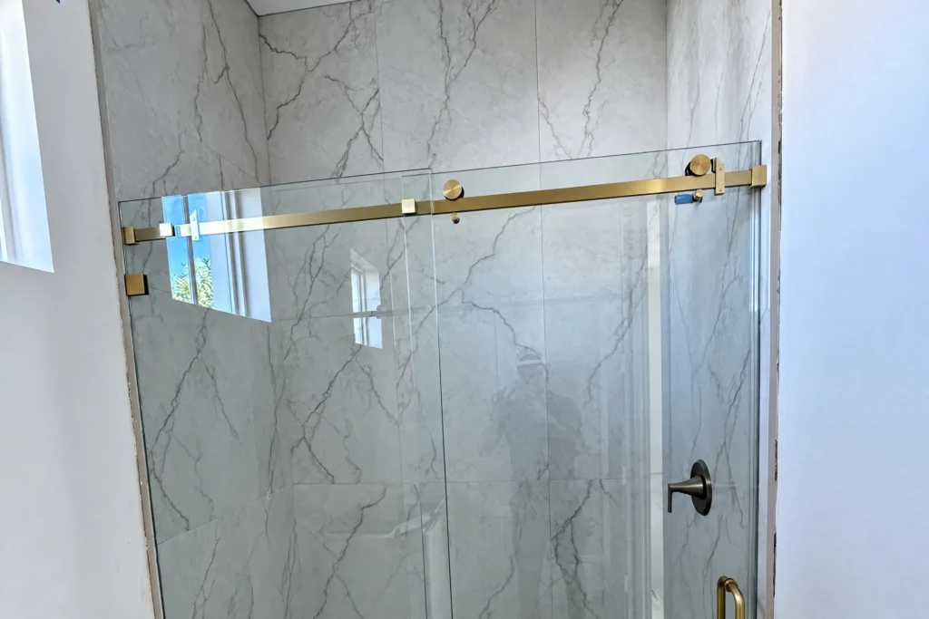 Frameless glass shower enclosures in a Palm Beach Gardens residence by ACG Glass & Metals