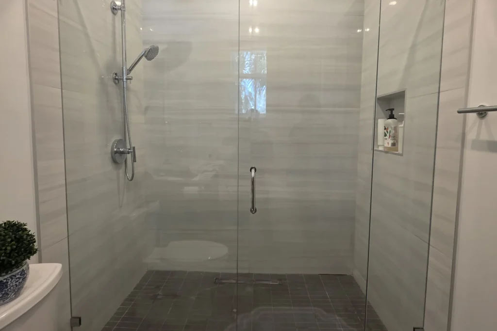 Frameless glass shower enclosure at the Stoney Drive residence in Palm Beach Gardens, FL