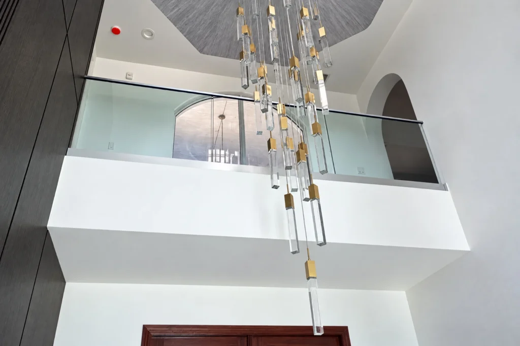 Interior glass railing with base shoe and top cap at the Via Palacio residence in Palm Beach Gardens, FL