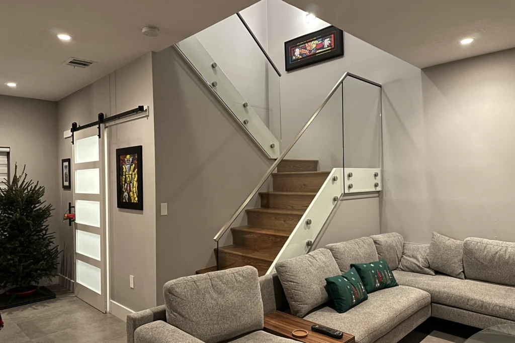 Interior glass stair railing on brushed stainless standoffs with a low profile cap rail, Weeping Willow Way residence in Hollywood, FL, by ACG Glass & Metals