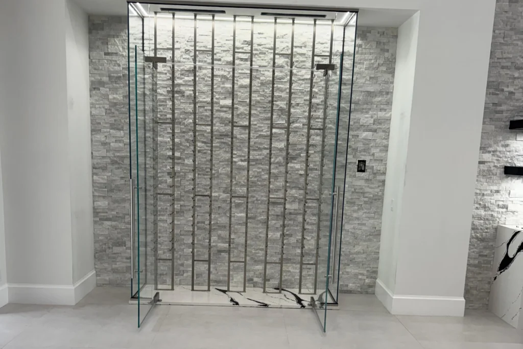 Frameless low iron glass wine enclosure with swing doors in a Palm Beach Gardens residence by ACG Glass & Metals